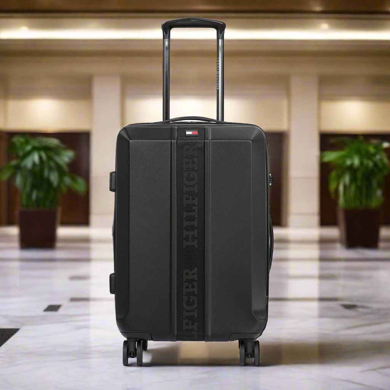 Tommy Hilfiger Arbor Polycarbonate Trolley Bag in Black — lifestyle shot in hotel lobby