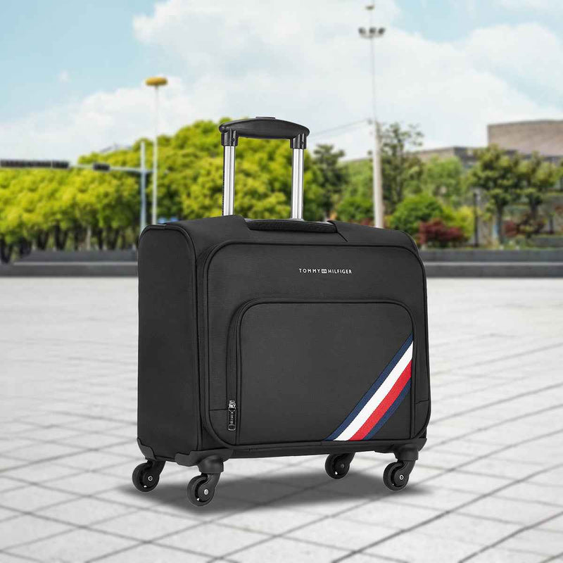 Tommy Hilfiger Roosevelt Overnighter Soft Luggage in Black — lifestyle shot outdoors on a paved plaza