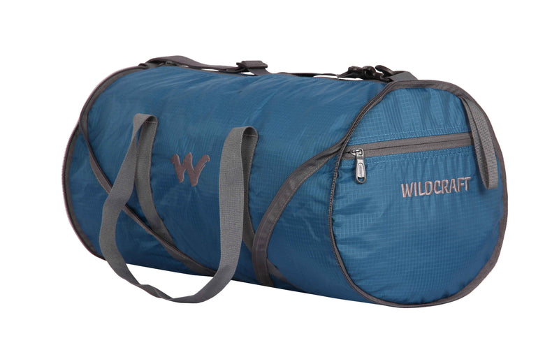 Wildcraft Frisbee Compressible Duffle Bag in Teal — three-quarter view showing round end and zip pocket