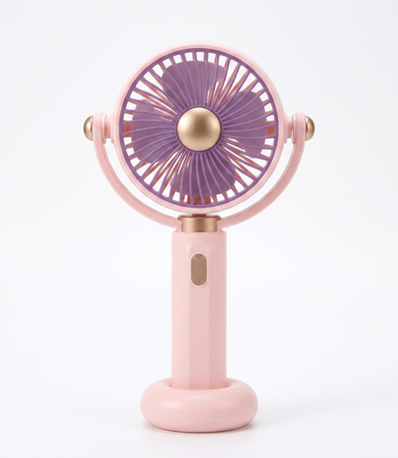 LS rechargeable handheld mini fan in pink with purple blades and antique-gold centre cap, standing upright on its round base