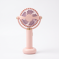 Rear view of the LS pink handheld mini fan showing the radial back grille, hinged yoke and weighted base